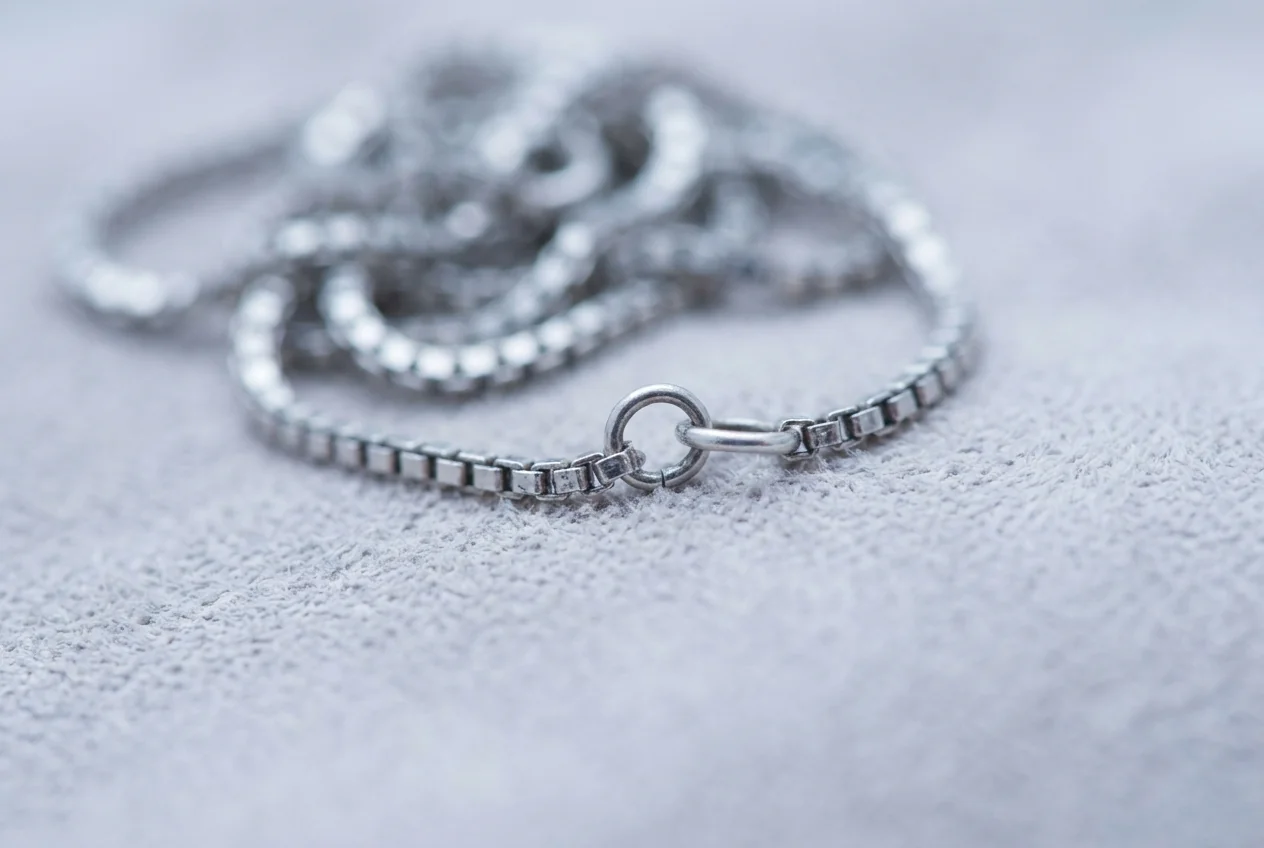 Macro of a fine silver box chain with one link opened